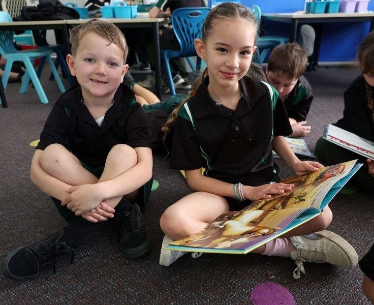 Two students sitting together and reading